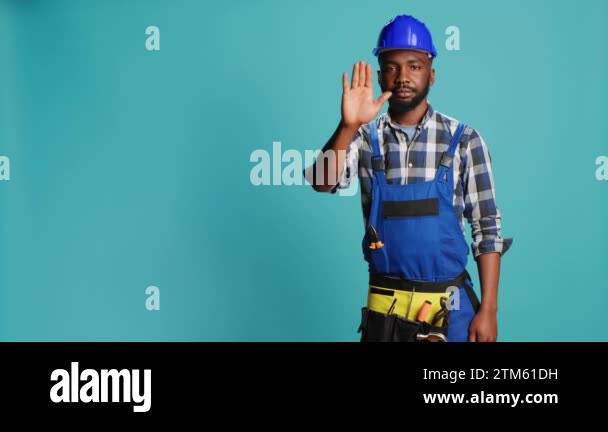 Construction worker raising hand doing stop sign, showing denial and ...