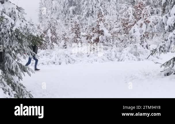 A young caucasian man rides a sitting girl on a sled while running ...