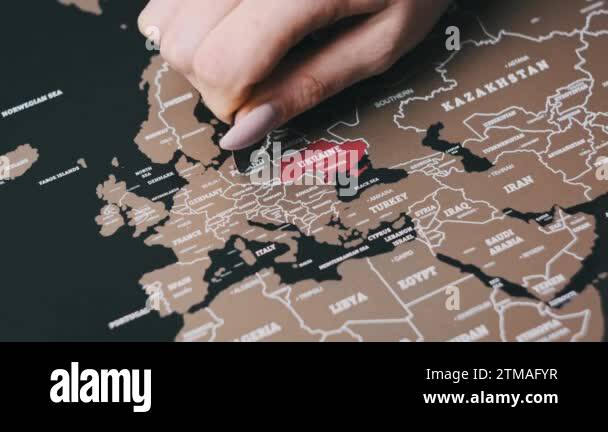 Female hand scratching the surface of a scratch map with Poland country 