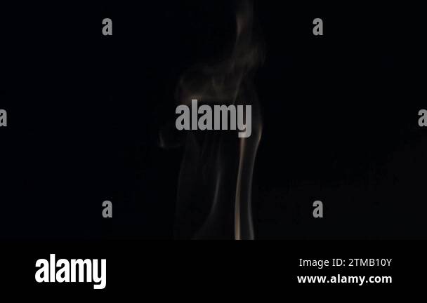 A beautiful wisp of smoke on a black background, with a warm tone that evokes a sense of coziness and comfort.