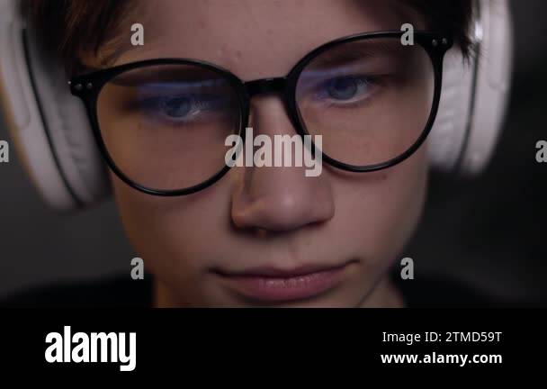 Gamer Reflection Young gamer man in glasses with screen reflection and headphones ...