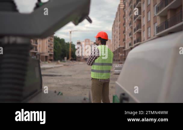 Hse Engineer Outside Confident engineer building architect in hard hat stands outside with ...