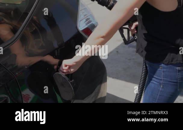 A man uses a fuel pump to fill up a car at a gas station Stock Video ...
