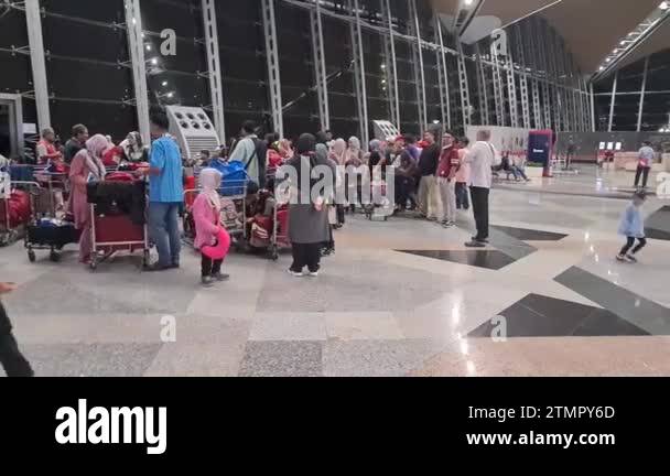 Muslim men and women waiting in a queue at a crowded airport Stock ...