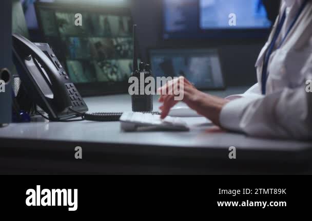 Female security officer works in police monitoring center. Woman types ...