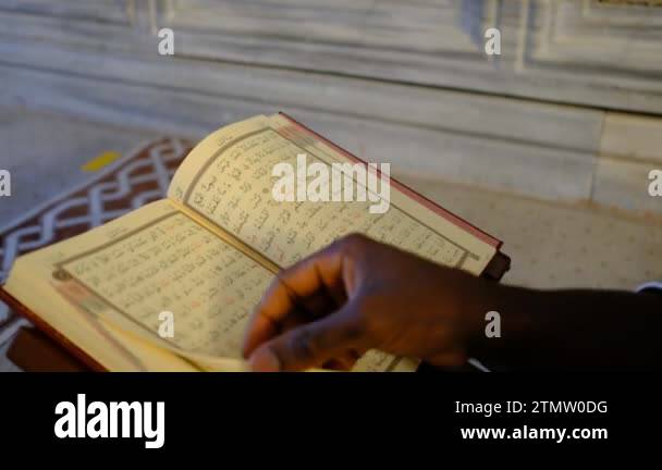African Man hand reading quran, the teenager is rummaging through the ...