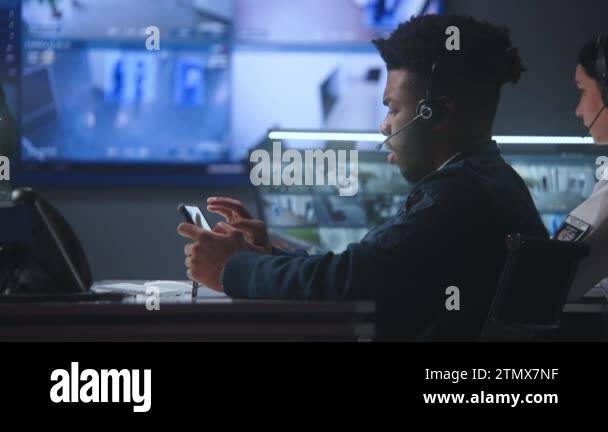Security operators in headsets control CCTV cameras. Woman uses ...