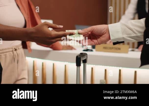 Close up of thankful hotel guest tipping helpful bellboy after ...