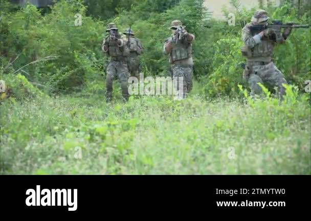 Smart teamwork of soldiers walking forward and attacking enemy during ...