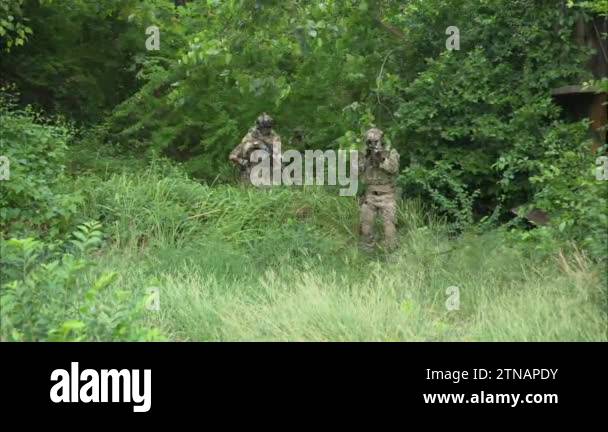 Smart teamwork of soldiers walking forward and attacking enemy during ...
