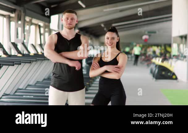 In-sync and ready A young man and woman striking a pose in the gym ...