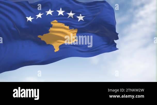 National flag of Kosovo waving in the wind on a clear day. Blue with a ...
