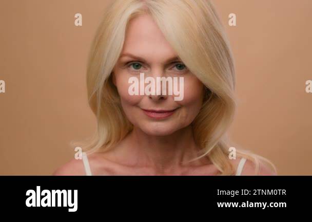 Caucasian middle-aged elderly mature woman in beige studio background nude natural beauty