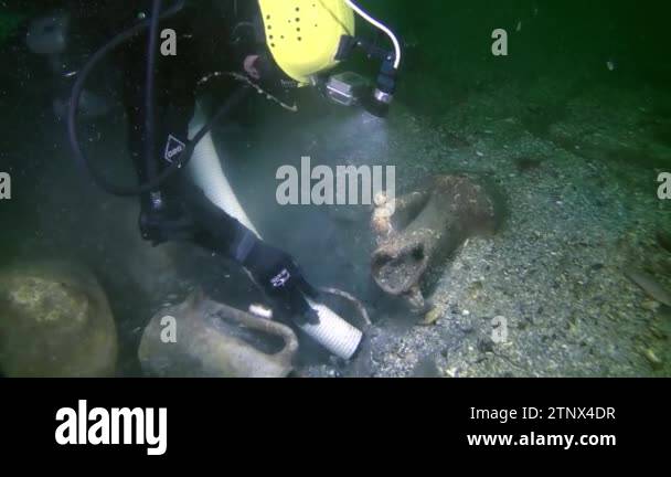 Underwater archeology: A research diver uses a hydraulic pump to suck ...