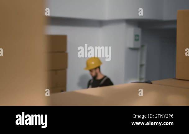African american employee in warehouse handling cardboard boxes full of ...