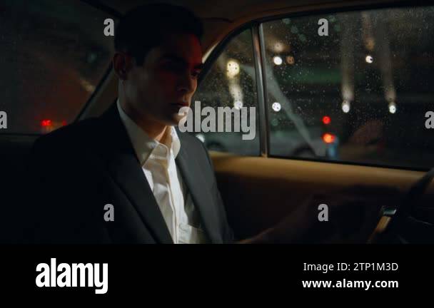 Focused man tapping computer screen in evening vehicle closeup. Serious ...