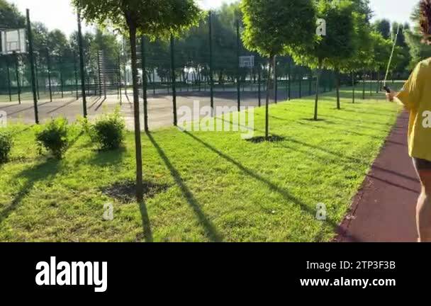 Rear view multiracial young woman engages morning workout at landscaped ...