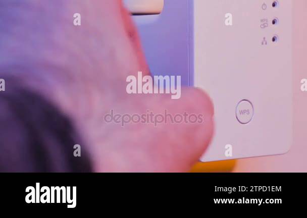 Man unplugs ethernet cable from WiFi extender device which is in