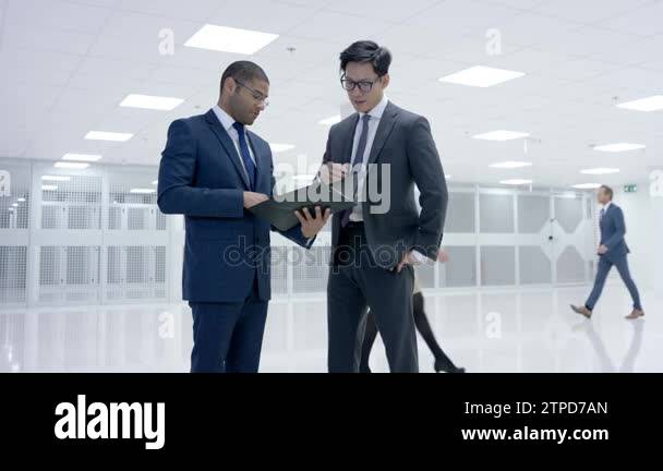 Business people looking around large modern data center with rows of ...