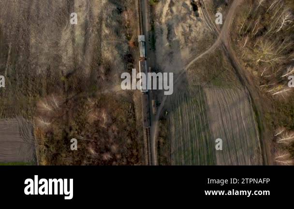Topl view of A locomotive and two carriages move along a narrow gauge ...
