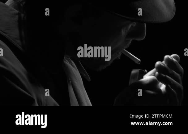 Noir film detective standing in the dark and smoking a cigarette, he is