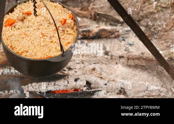 4K.Cooking in wood on campfire with dolly shot. Tasty pilaf, rice in ...