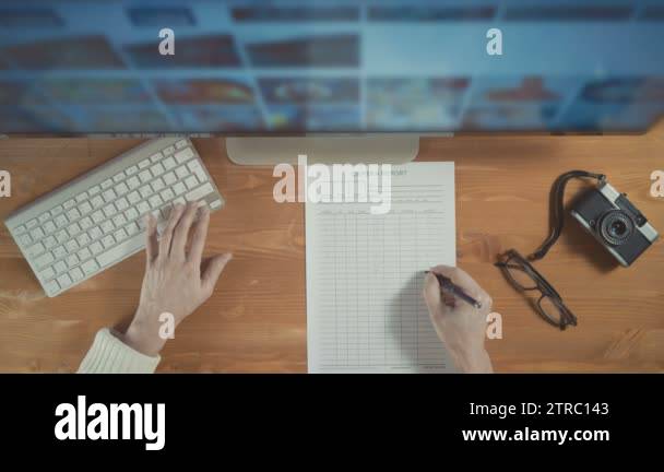Photographer using display and keyboard to select photos from computer ...