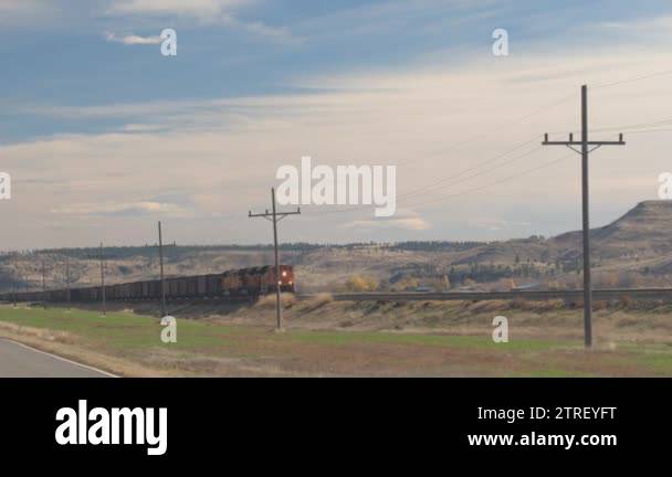 CLOSE UP: Locomotive hauling a loaded freight train wagons along the ...