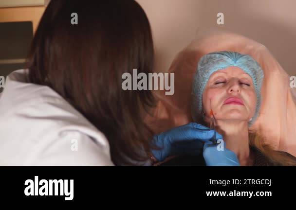 Shot of the doctors arm who put the injection implant under the skin of ...