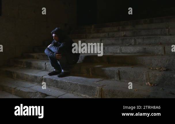 4K video lateral panning 24 fps of young desperate wasted man in hood ...