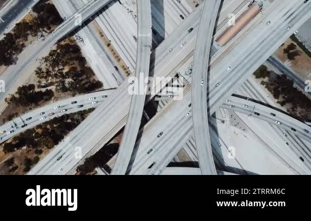 Top view drone rotating fast above big freeway interchange with cars ...