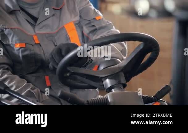 close - up steering wheel and levers. man driving a forklift through a ...