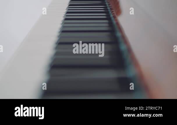 Keyboard of piano Back-focus slow tilt down over black and white keys ...