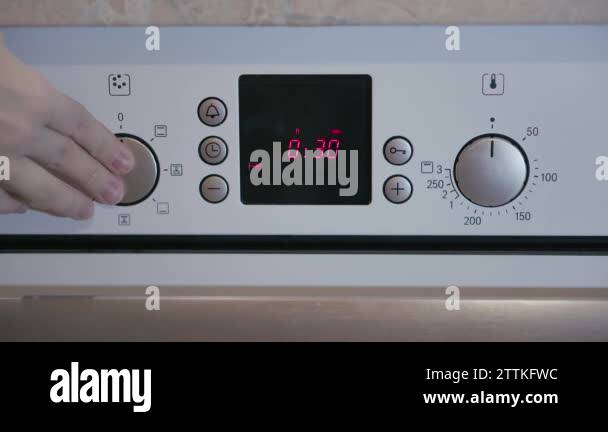 Female hand includes Metallic Toggle Switch of the Cooker Oven. Close ...