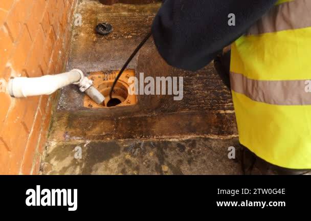 Plumber wearing bright yellow safety vest and working by residential ...
