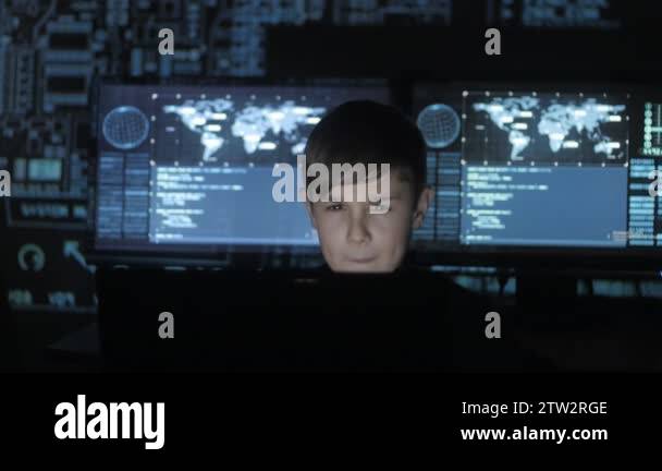 young prodigy boy hacker programmer working at the computer in the data ...
