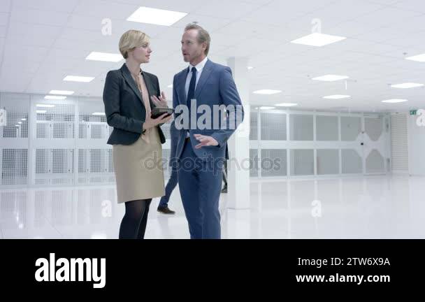Business people looking around large modern data center with rows of ...
