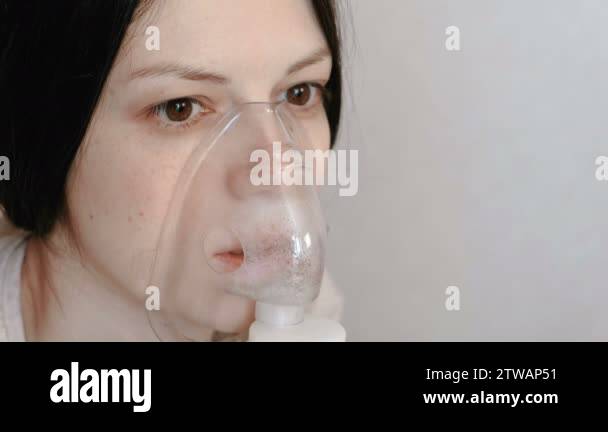 Use nebulizer and inhaler for the treatment. Closeup womans face ...