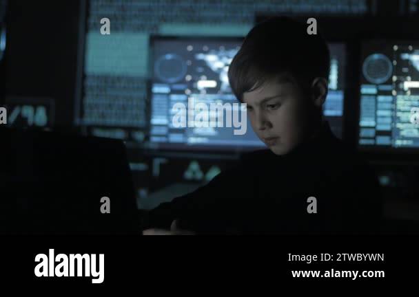 Cute teen boy programmer working at a computer in the data center ...