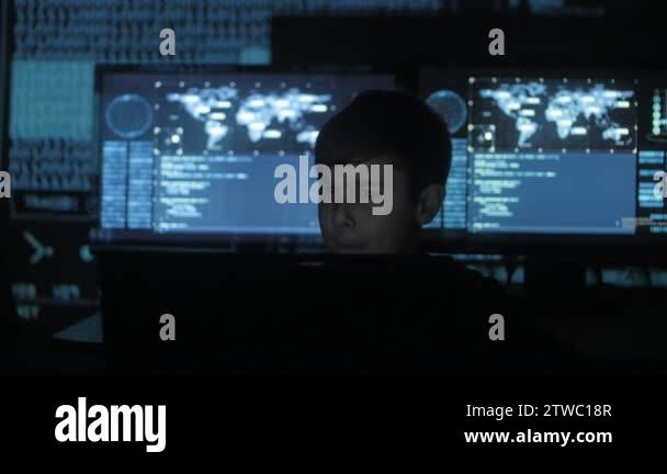 Cute teen boy programmer working at a computer in the data center ...