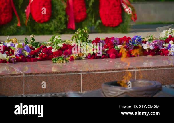 Red and white funeral flowers with ribbon on the Eternal Flame memorial ...