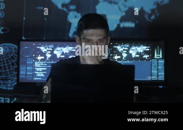Hacker programmer in glasses is working on computer while blue binary ...