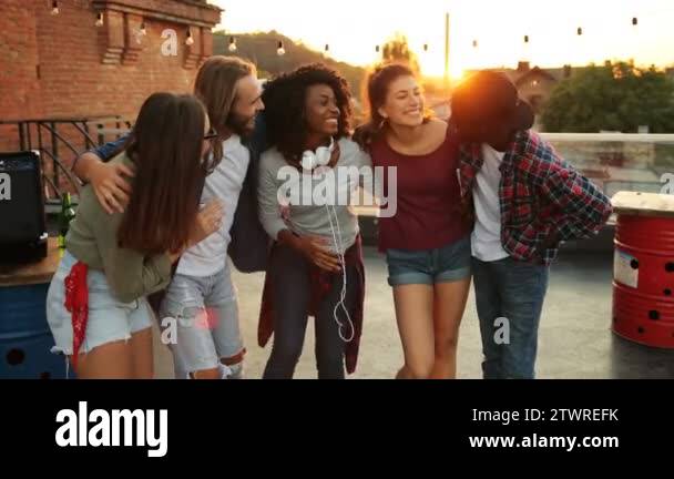 Portrait of mixed races friends hugging and posing to the camera at the ...