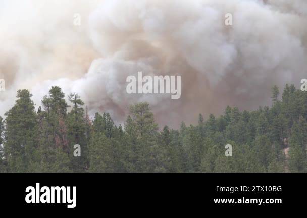 CLOSE UP: Thick black smoke trail rising and spreading fast across the ...