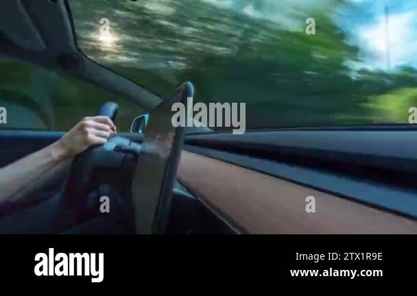 Person driving a new Tesla Model 3 in autopilot. The model 3 is set to ...