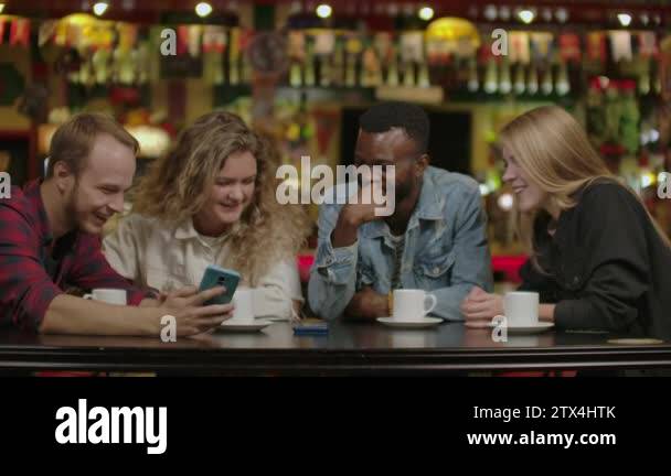 Friends Talking Using Phones Happy multi-ethnic group of friends talking using smartphones at. Happy ...