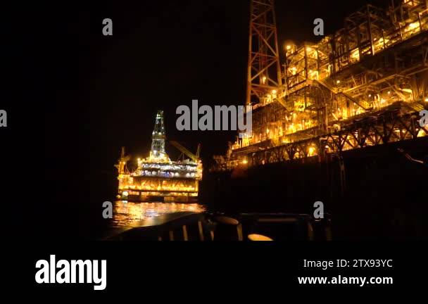 FPSO tanker vessel near Oil platform Rig at night. Offshore oil and gas ...