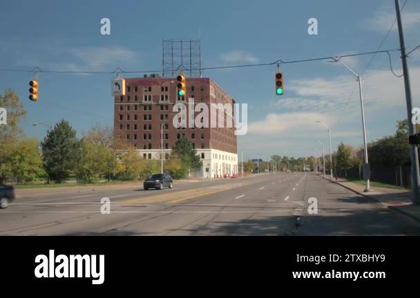 CLOSE UP: Driving along the street towards red brick-built derelict ...