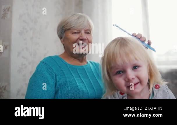 Grandmother Brushing Her Granddaughters Hair Girl Looking In The