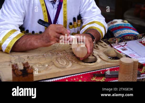 Carving wood, male artist creates female figure by using hammer and ...